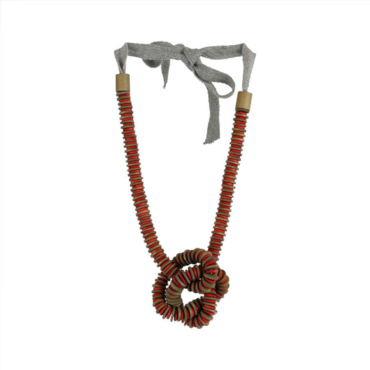 Handmade red wooden necklace featuring a knotted pendant and grosgrain ribbon neckline. Ethically crafted by a sustainable fashion accessories manufacturer.

